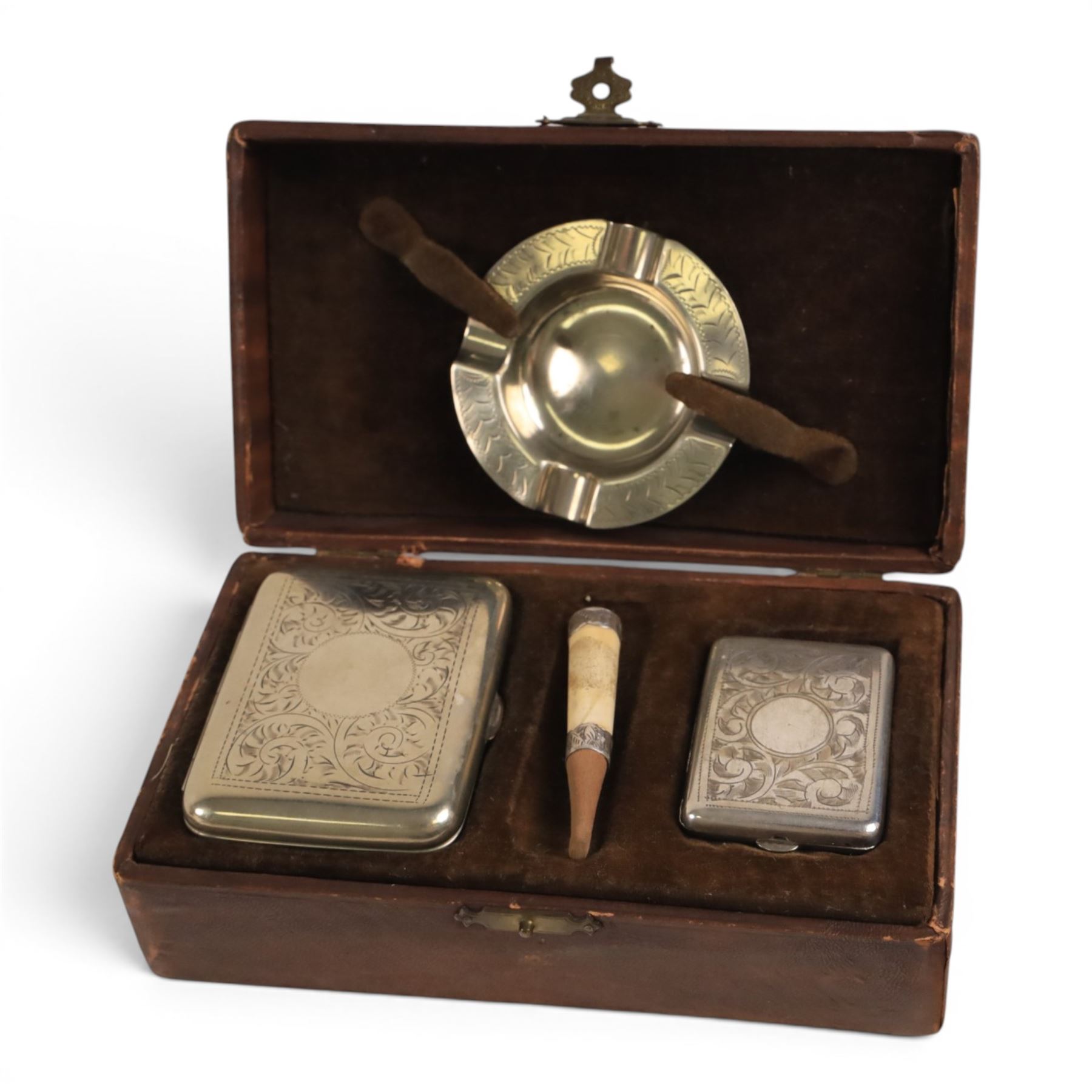 Three cigarette cases, modelled as bank notes, together with a smokers set including ashtray, cigarette case, ligher and cigarette holder, cased and other cigarette holders 