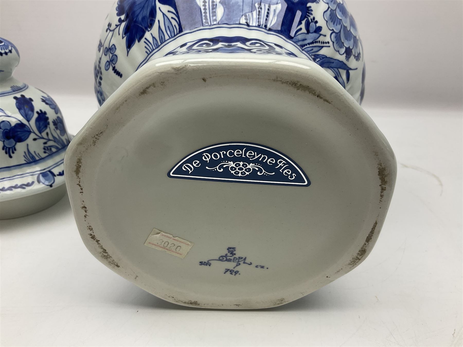 De Porceleyne Fles Delftware blue and white covered jar, of fluted baluster form, with floral and insect decoration, upon an octagonal foot, the octagonal cover with urn shaped finial, H32cm