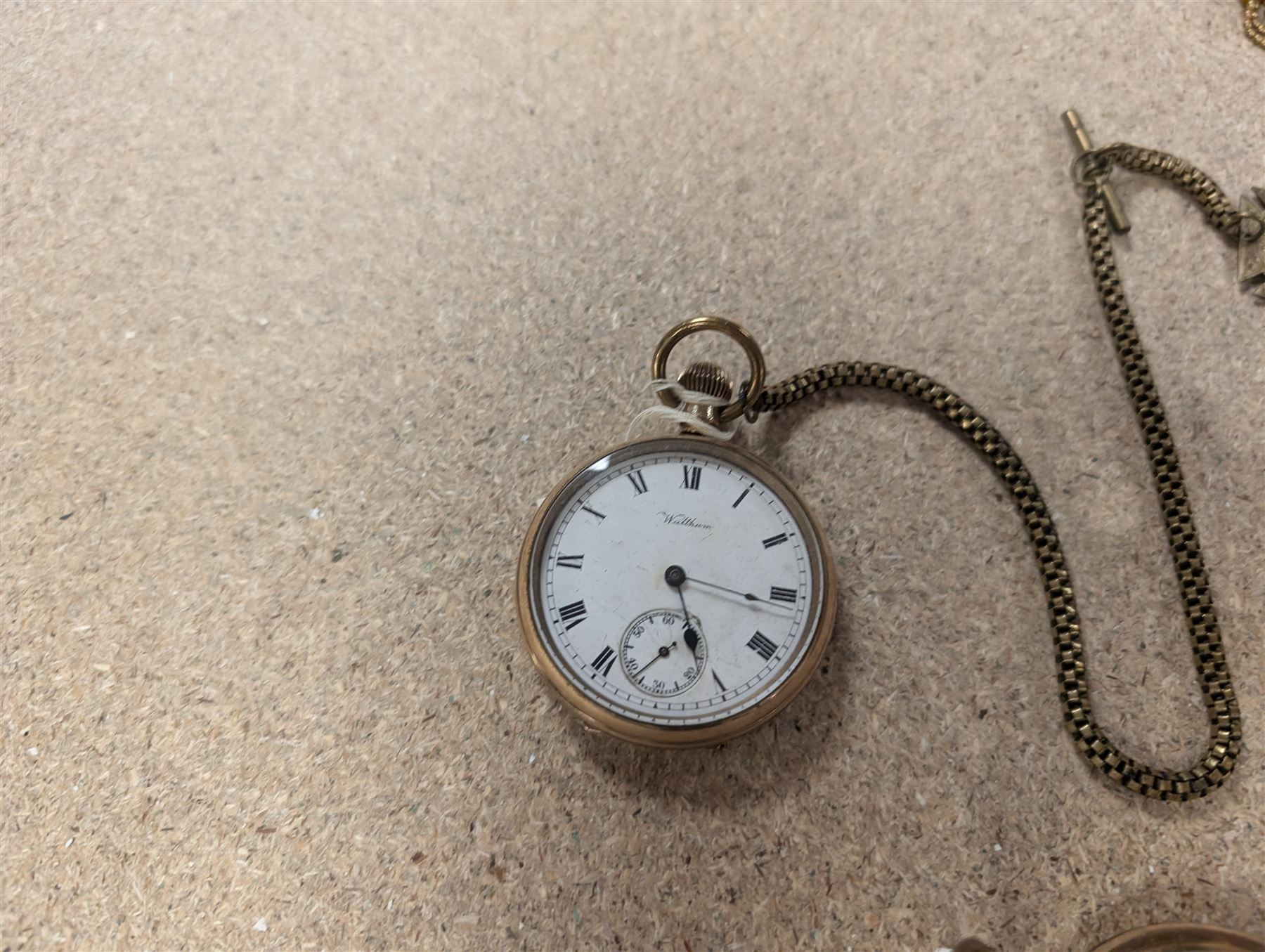 Four early 20th century gold-plated keyless pocket watches, three by Harris Stone Leeds, Waltham and Elgin and two gold-plated watch chains
