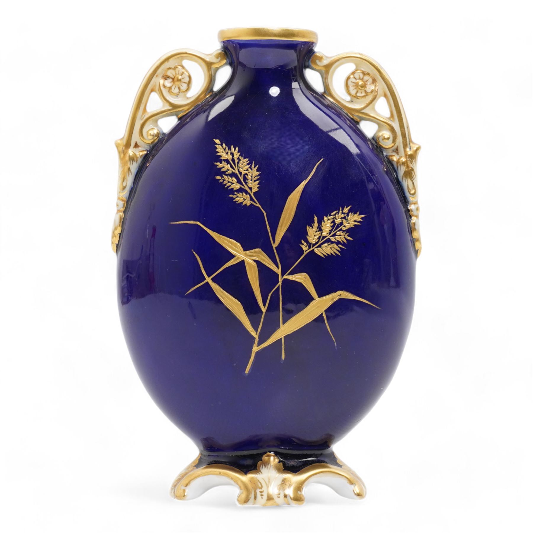 Early 20th century Royal Worcester loving cup, circa 1906, painted with a view of the River Severn and flowers to the reverse, H13cm, Grainger & Co. Worcester twin handled vase, the oval body painted in the Aesthetic style with ferns and grasses in gilt, against a cobalt blue ground, with scrolled handles and quatrefoil foot, H17cm (2)