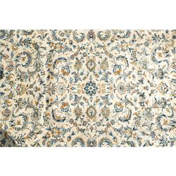 Central Persian Kashan hand-knotted carpet, ivory field profusely decorated with an all-over scrolling vine, palmette, and lotus design in shades of soft blue, pale gold, and green within floral borders