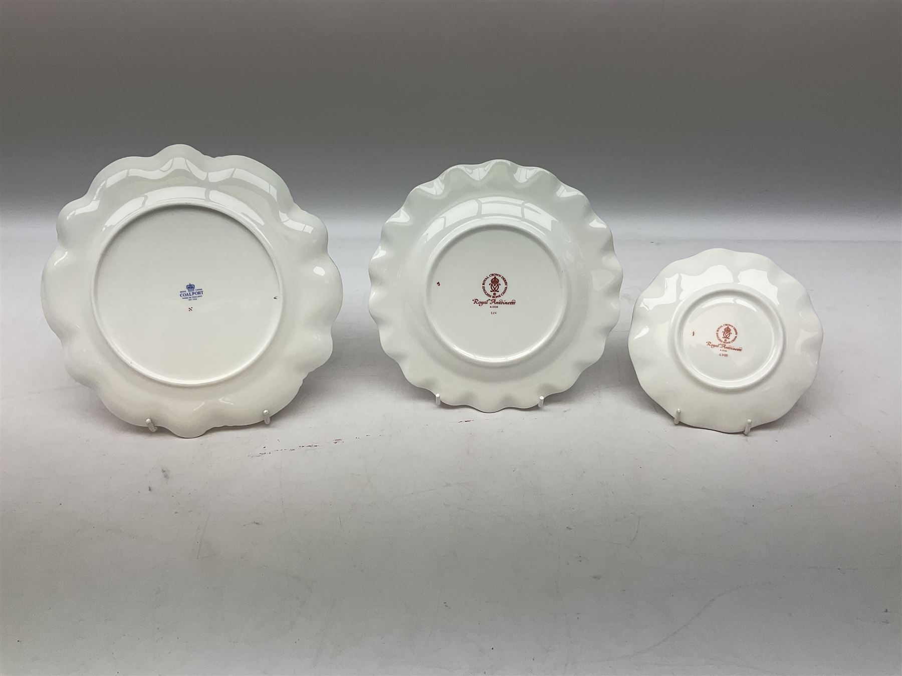 Coalport Revelry pattern tea and dinner wares, comprising nine dinner plates, four salad plates, eleven side plates, sauce boat and stand, ten teacups and ten saucers, and preserve pot and cover, together with a Coalport plate of shaped form decorated with pink roses, and a Royal Crown Derby Royal Antoinette pattern trio