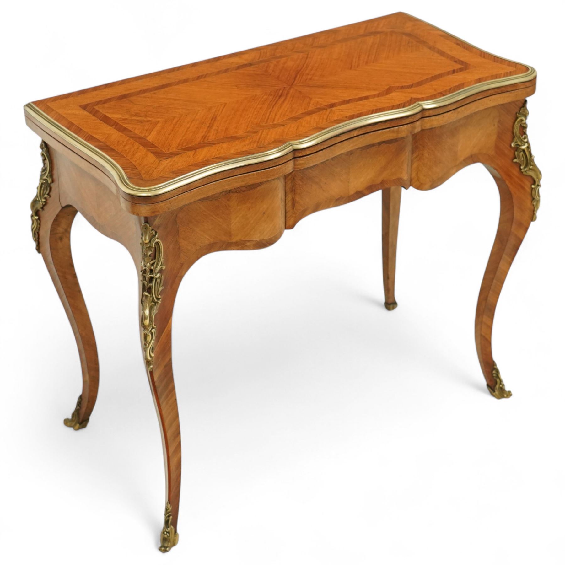 Early 20th-century Louis XV-style kingwood and tulipwood marquetry card table, shaped rectangular hinged top revealing baize-lined interior, with quarter-veneered parquetry within crossbanded borders and mounted with a gilt bronze edge, above a serpentine frieze,  raised on cabriole legs with gilt bronze foliate mounts and sabots 