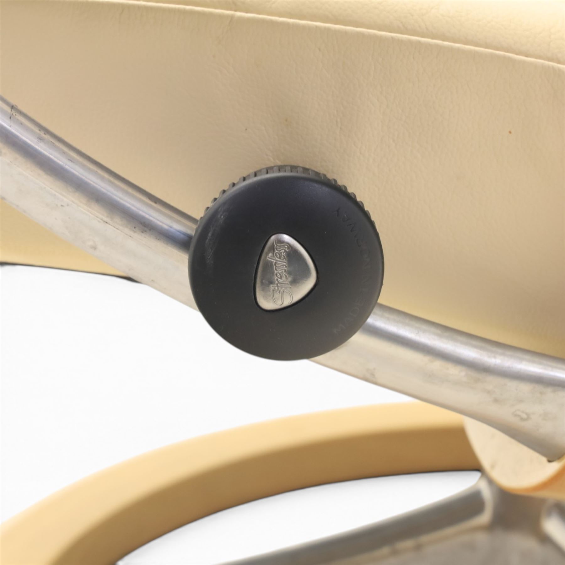 Ekornes - Stressless reclining beige leather armchair and stool, raised on brushed steel frame, light oak rotating base