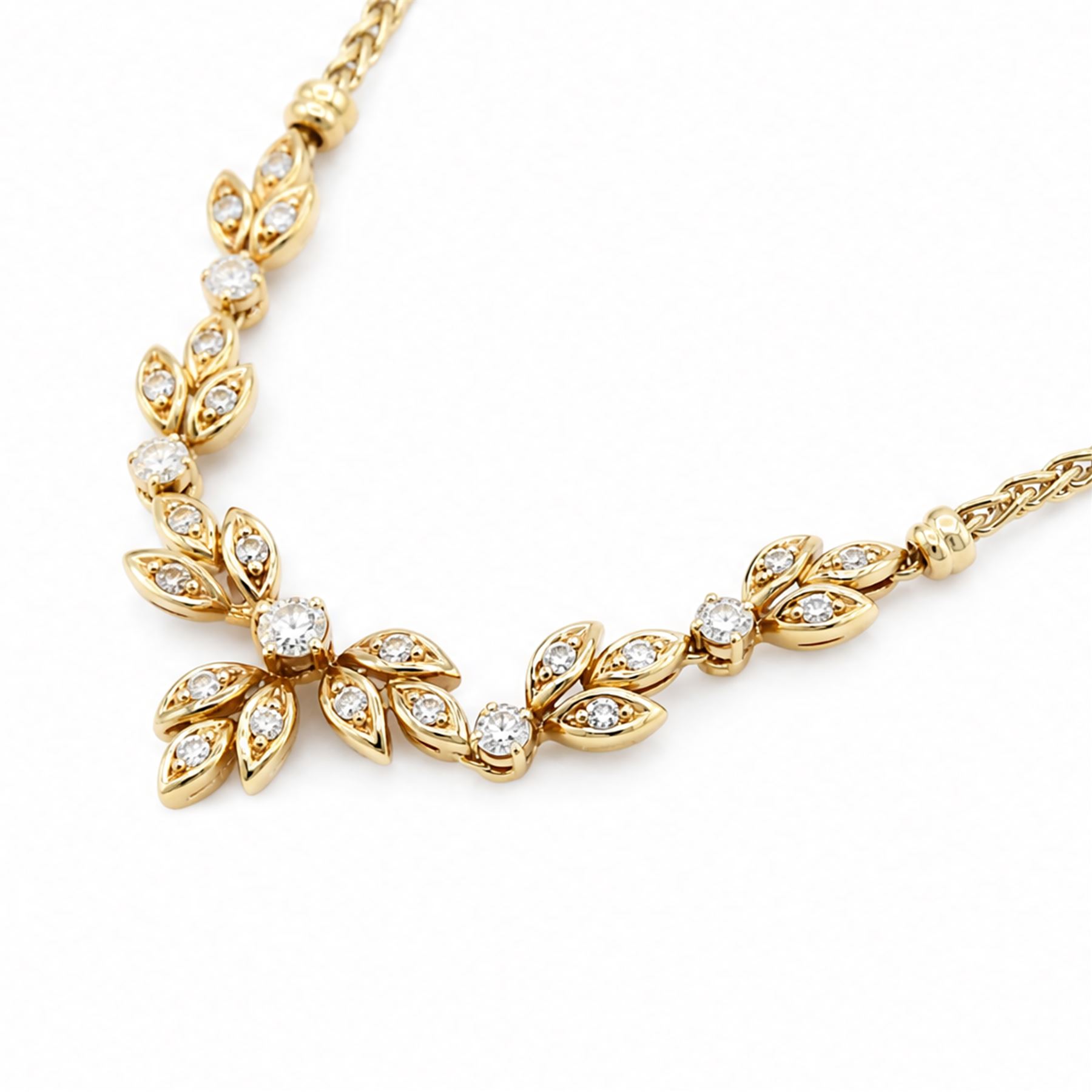 18ct gold diamond floral design necklace, five round brilliant cut diamonds, each spaced by leaf design links set with diamonds, to a Spiga link chain, Sheffield import mark 1989, total diamond weight approx 0.75 carat