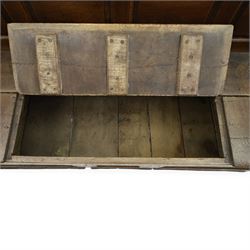 18th century oak high-back settle or hall bench, the panelled back and arm terminals over a hinged box seat, panelled front on short stile feet