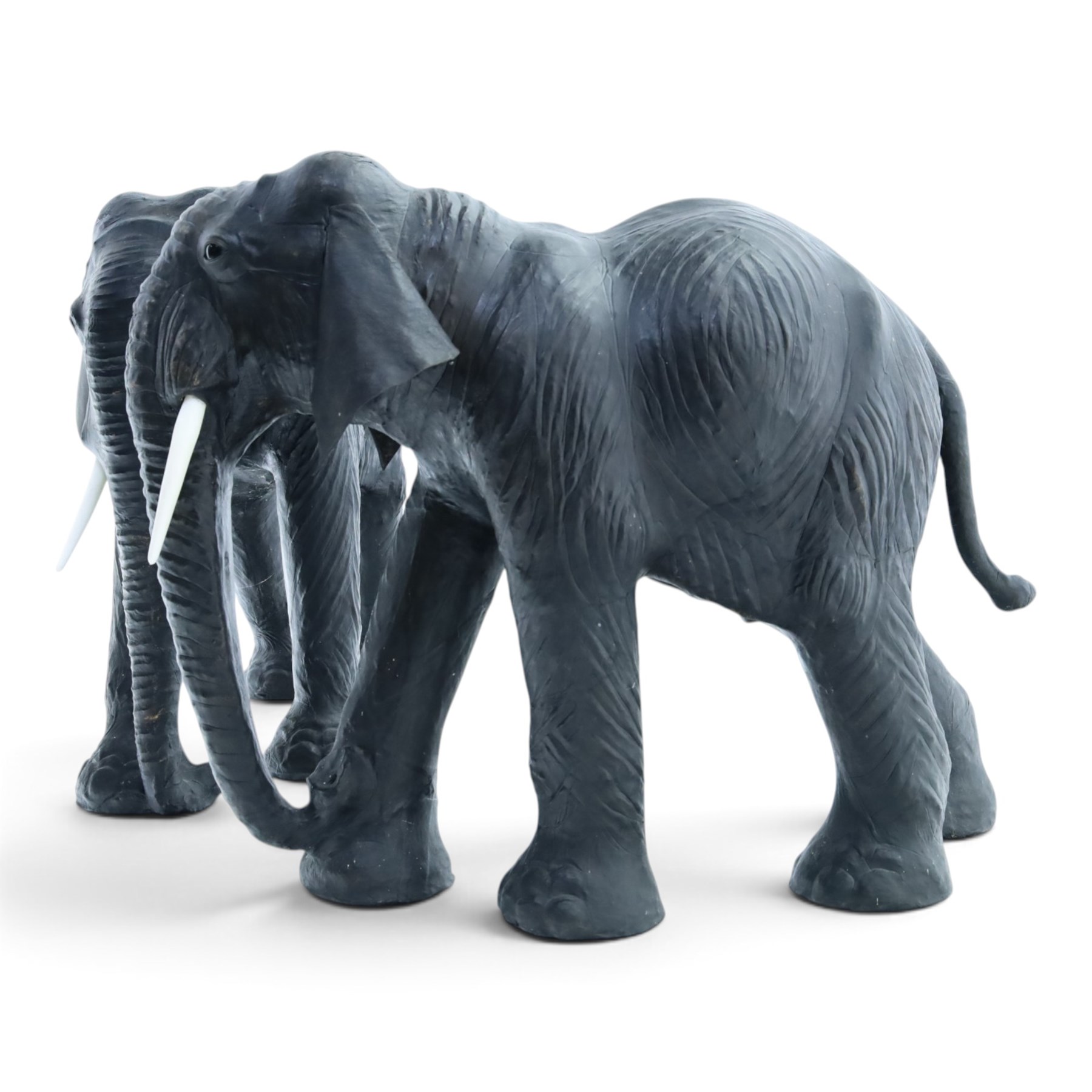 In the style of Liberty & Co - pair of 20th century ebonised leather elephants