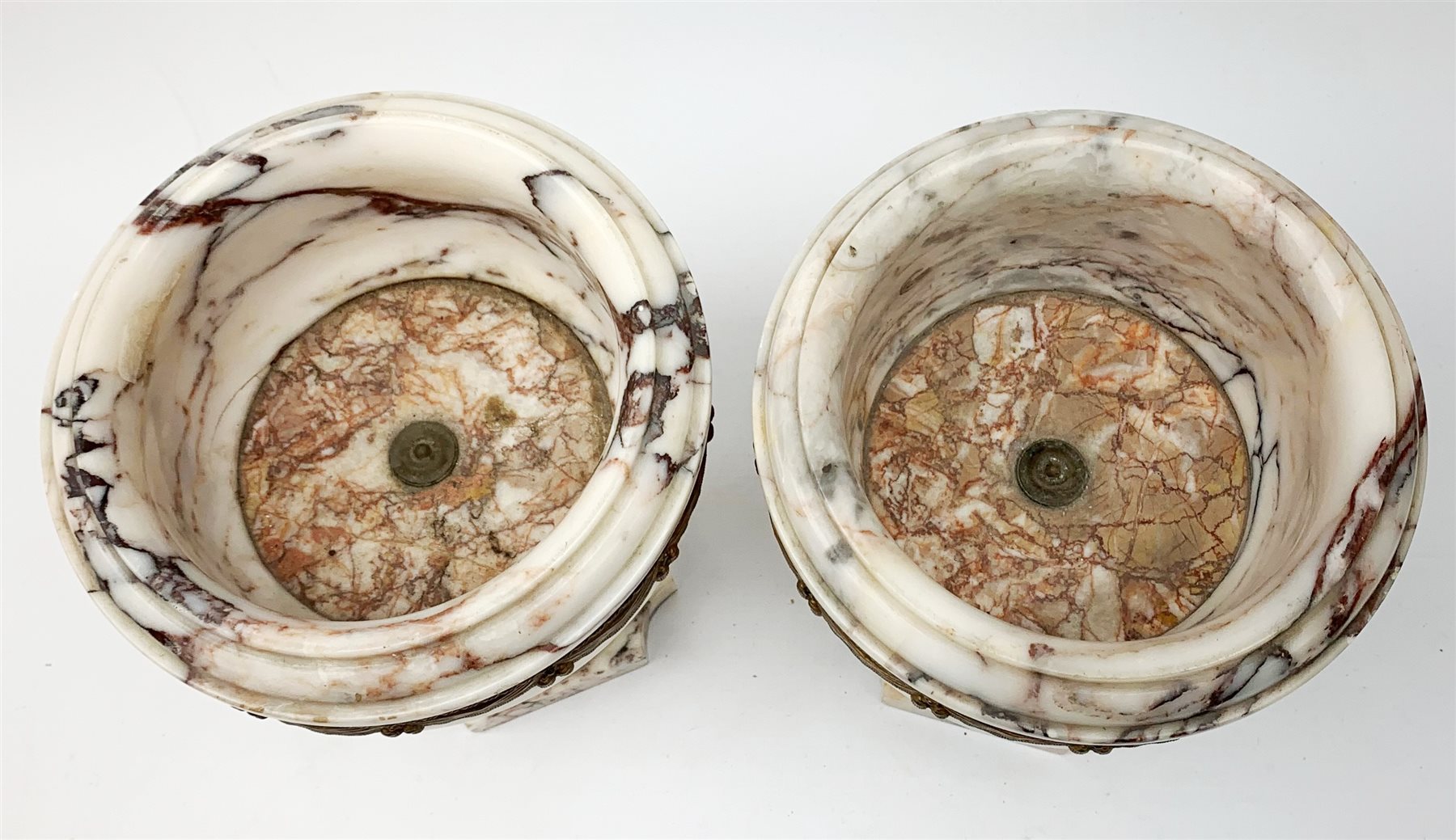 Pair of Neo Classical veined white marble urns, decorated with a metal band of classical drapes, raised upon a pedestal foot, H23cm