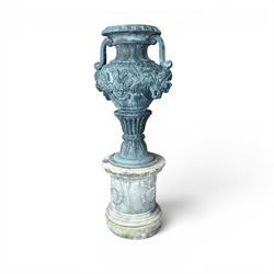 Large impressive Classical cast bronze center-piece urn, twin scroll handles with grape garlands, cherub masks and relief detail, raised on a circular cast stone pedestal with moulded detail