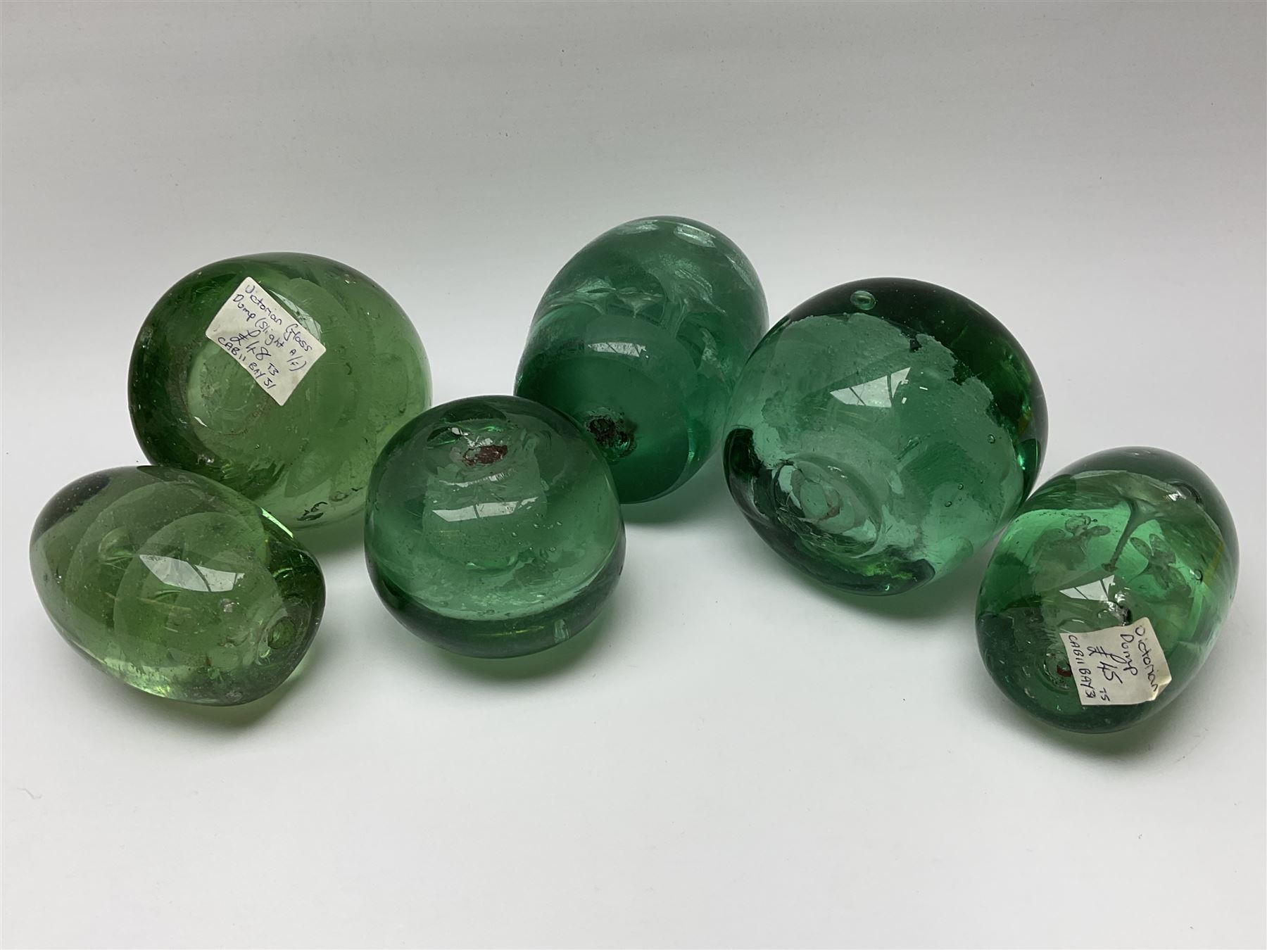 Six Victorian green glass dump paperweights, with internal foil flower