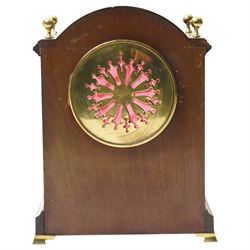 Edwardian-French mahogany cased mantle clock c1910 in a break-arch case with brass finials and recessed brass columns, with inlaid satinwood stringing and conche inlay to the front, raised on a short plinth with bracket feet, twin train movement with rack striking, sounding the hours and half-hours on a coiled gong.
With pendulum and key.
