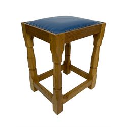 Brian Haw (former Mouseman carver) - Yorkshire oak stool, blue leather upholstered seat with stud band, on octagonal supports joined by plain stretchers