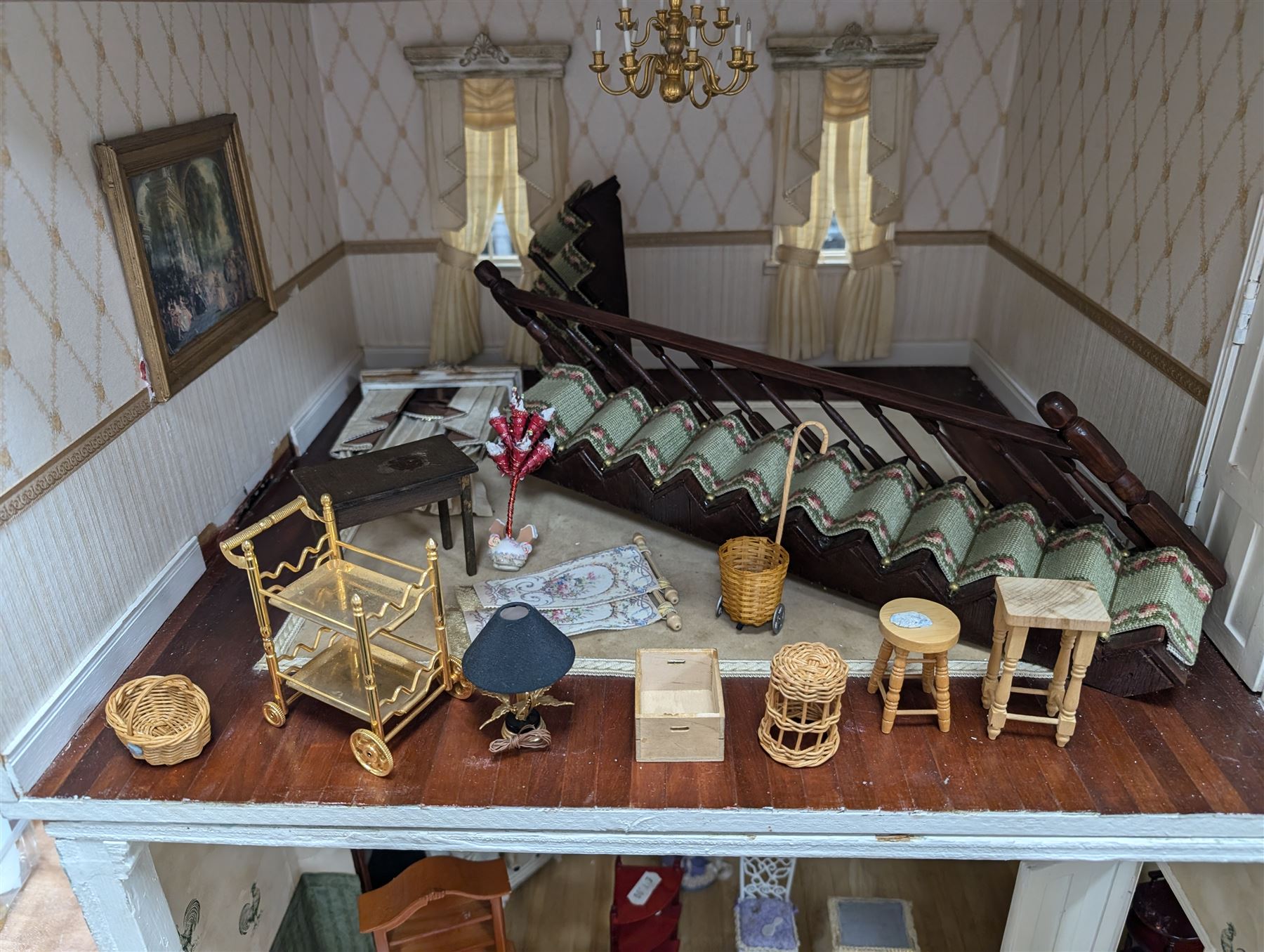 Two modern three storey dolls houses, each painted green with decorated interiors, both upon a single white wooden base, together with a large collection of dolls house furniture, accessories and figures 