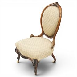 Pair of Victorian walnut framed ladies salon nursing chairs, oval cameo back with carved cartouche carved cresting rail, sprung seat upholstered in foliate patterned ivory fabric, shaped apron carved with scroll and cartouche decoration, on cabriole supports with moulded flower knees, retailed by David Hick Interiors, Jersey
