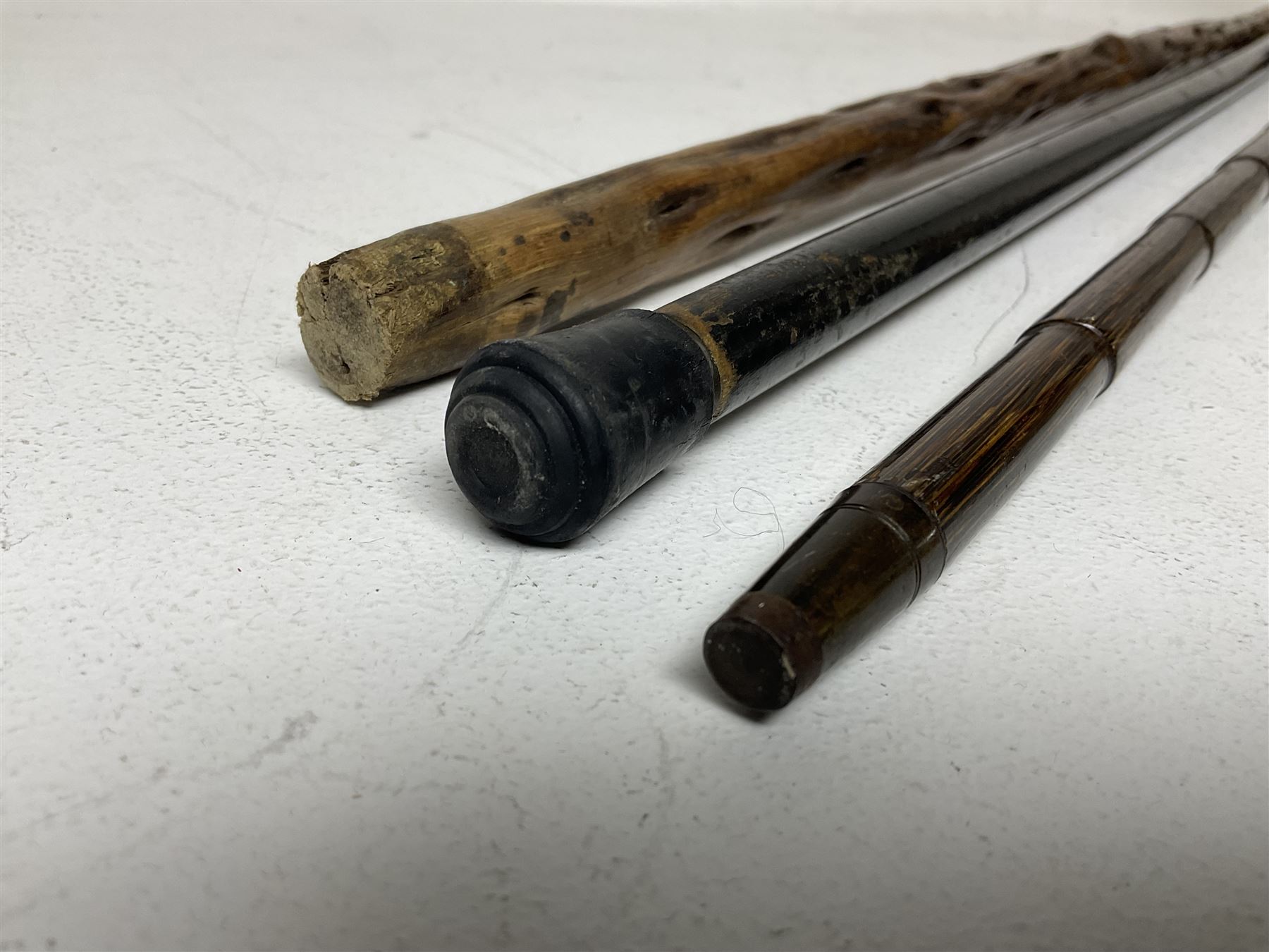 19th century painted bamboo walking cane, the handle carved as a fox with glass eyes, with gilt metal stamped LB, together with an ebonised wooden walking stick, with horn pommel and hallmarked silver collar and a curved wooden walking stick, with monogrammed white metal cap, tallest L90cm