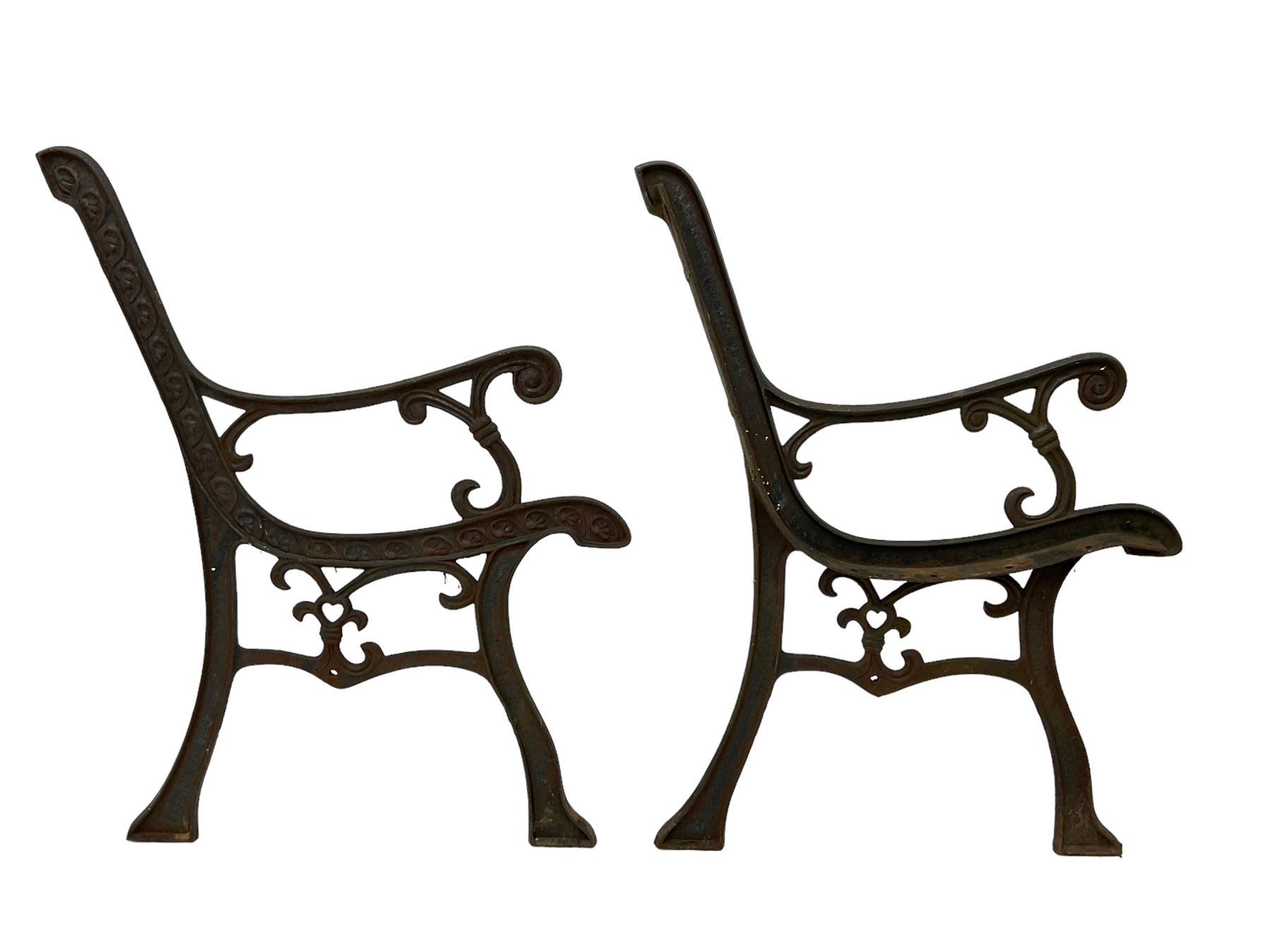 Pair cast iron garden bench ends decorated with scrolling design (H83cm), another pair of cast iron bench ends (H78cm), and a cast iron bench back decorated with foliage branches and roses (W110cm x H30cm)