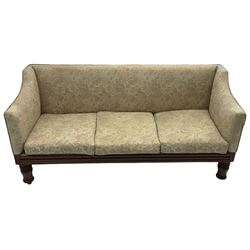 Victorian mahogany framed three-seat settee, upholstered in floral pattern fabric, on turned feet with brass and ceramic castors 