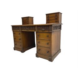 Late 19th century heavily carved oak twin pedestal desk, rectangular top with two raised trinket or correspondence structures each with three drawers, rectangular top over three frieze drawers carved with acorn and oak leaf decoration, each pedestal with three drawers with acorn husk shaped handles