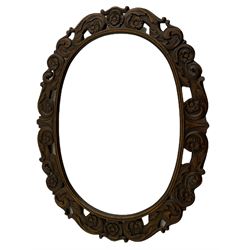 20th century oak framed mirror, carved with scrolled foliage and flower heads, oval plate