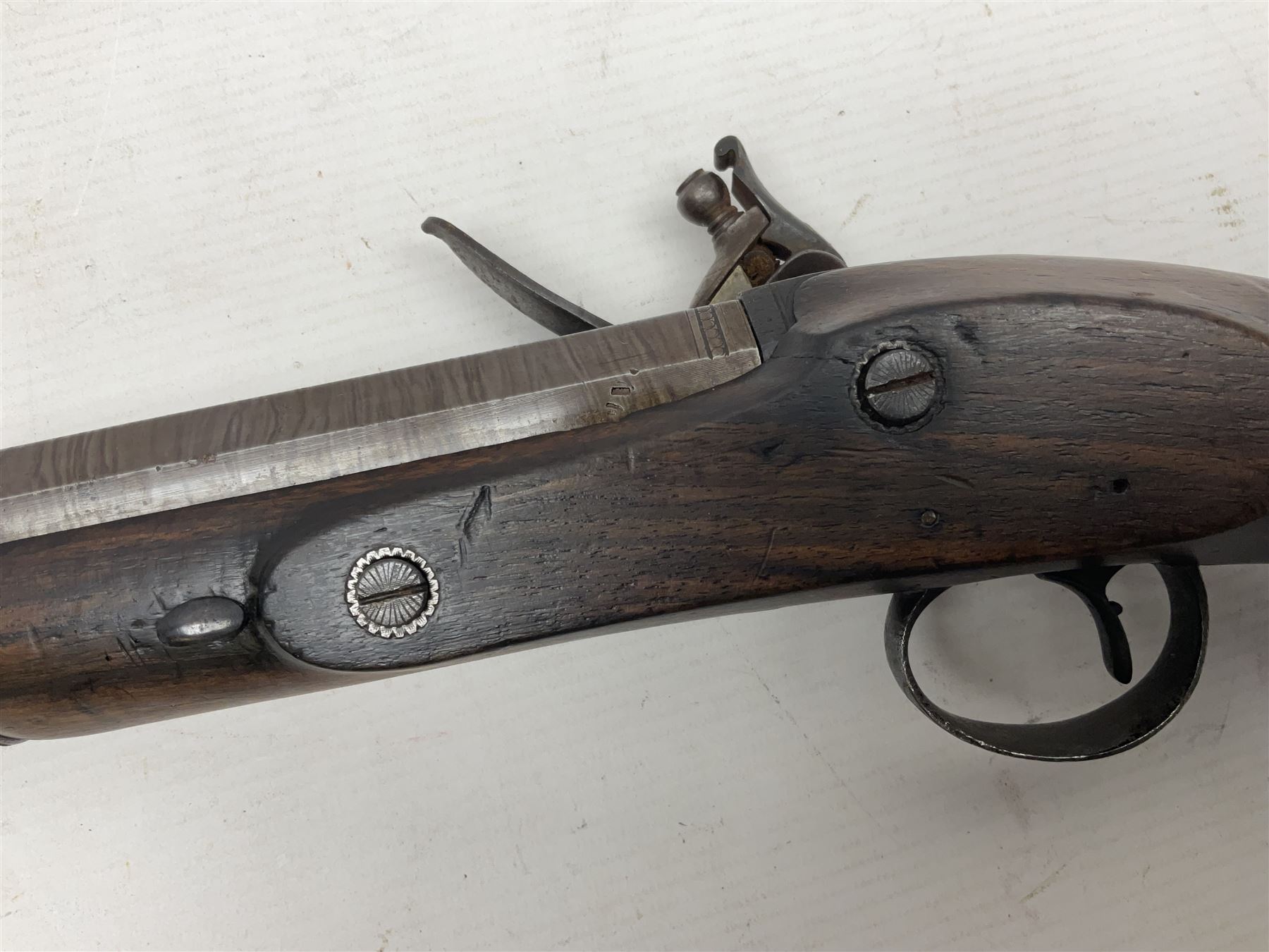 Early 19th century 16-bore flintlock single barrel travelling pistol, the 21.5cm stub twist octagonal barrel with two barrel pins and ramrod under, engraved lock plate with roller frizzen, engraved trigger guard with pineapple finial, walnut stoock with chequered grip L40cm overall