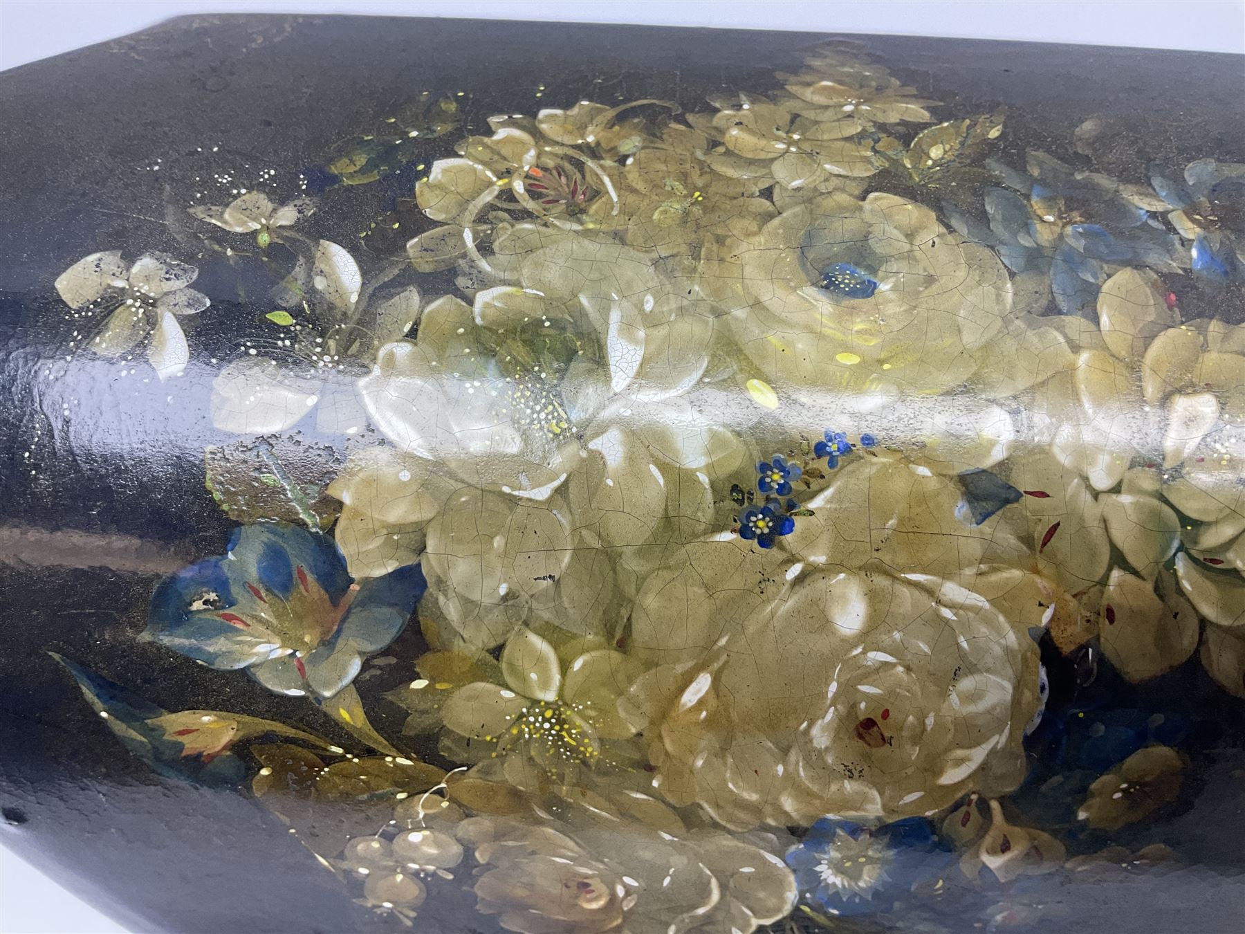 Victorian papier-mâché stationary box, of rounded wedge form with mother of pearl escutcheon, the hinged and curved cover and sides hand painted with floral sprays, opening to reveal a lined and fitted interior, H15cm L22cm D16cm