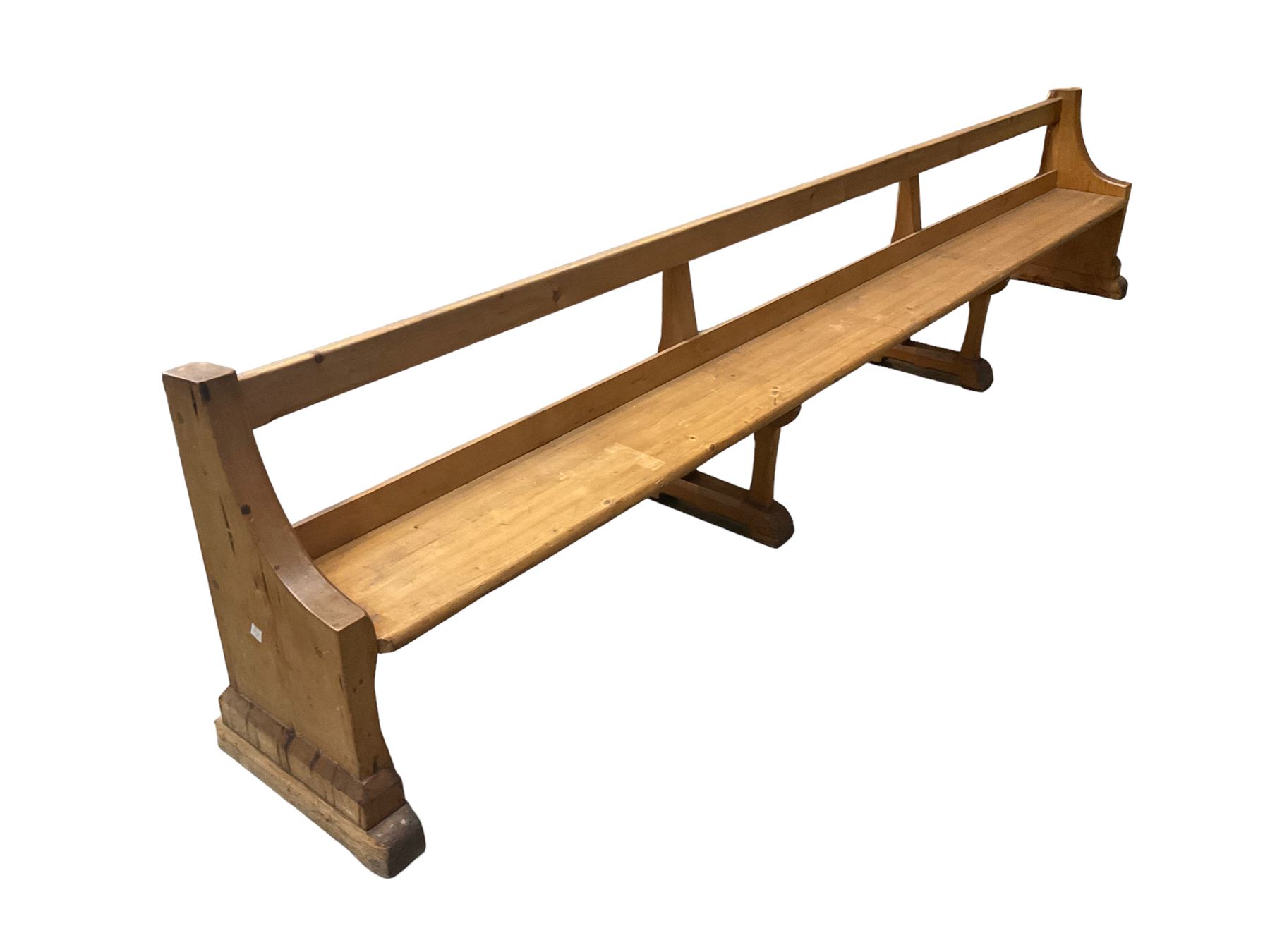 Early 20th century ecclesiastical pine bench or church pew, raised on chamfered supports with sledge feet