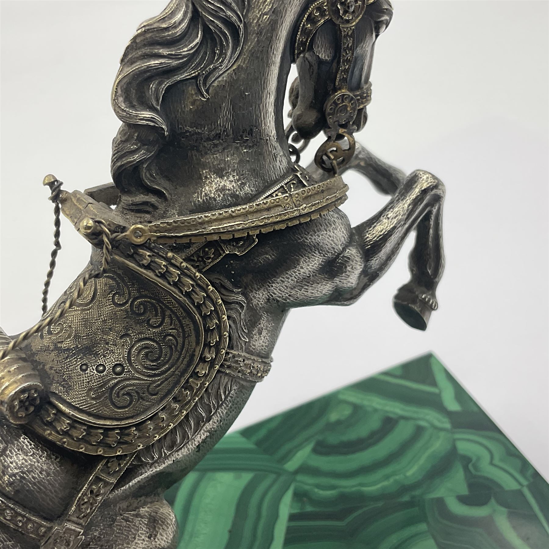 Modern silver model of a rearing horse, with ornate parcel gilt saddle and bridle, mounted upon a rectangular base, decorated with malachite panels to each side and upon four gilt bun feet, horse stamped 925, overall H14.5cm
