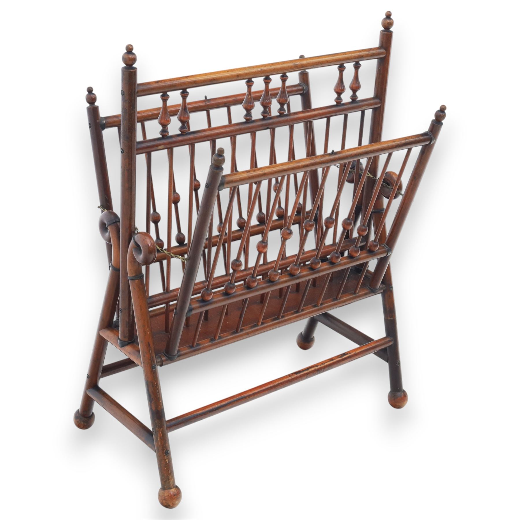 Arts and Crafts mahogany magazine stand, in the manner of Christopher Dresser, folding magazine stand, rectangular divided slatted compartments with turned spindle galleries and ball finials, the sides forming an X-frame action, raised on turned supports united by stretchers