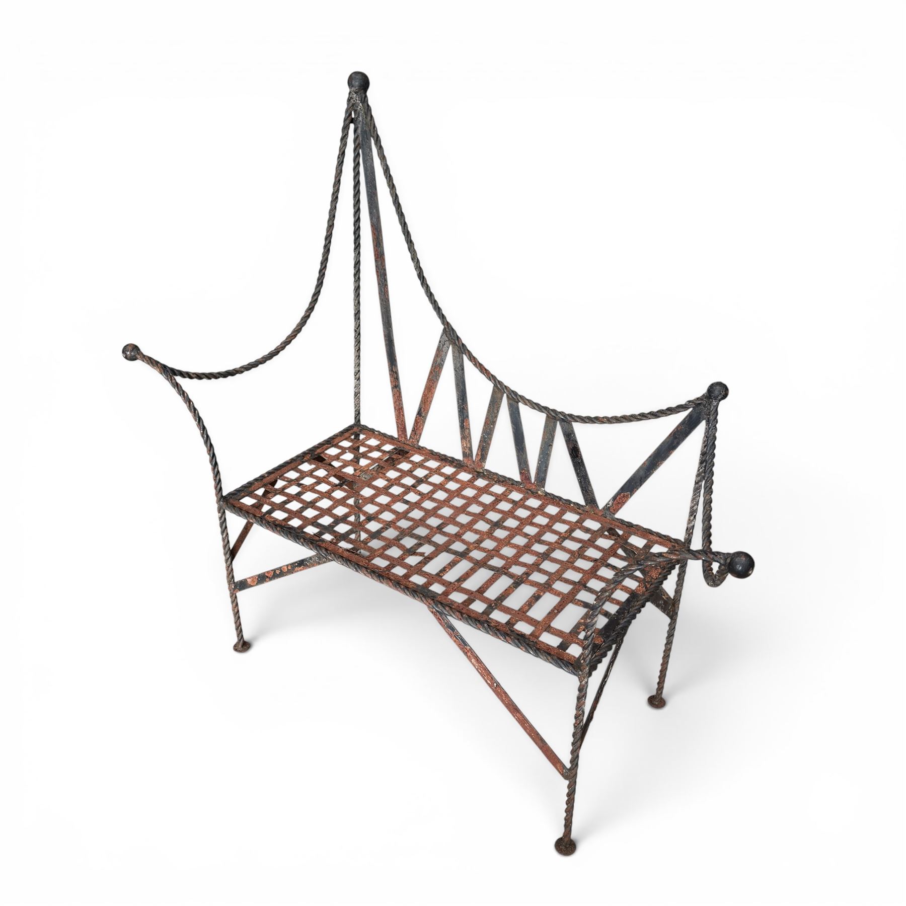 Victorian design wrought iron garden bench, with asymmetrical rope-twist frame, arched back and sides over out-swept arm terminals with ball finials, flanking a lattice seat, in antique black-painted weathered finish