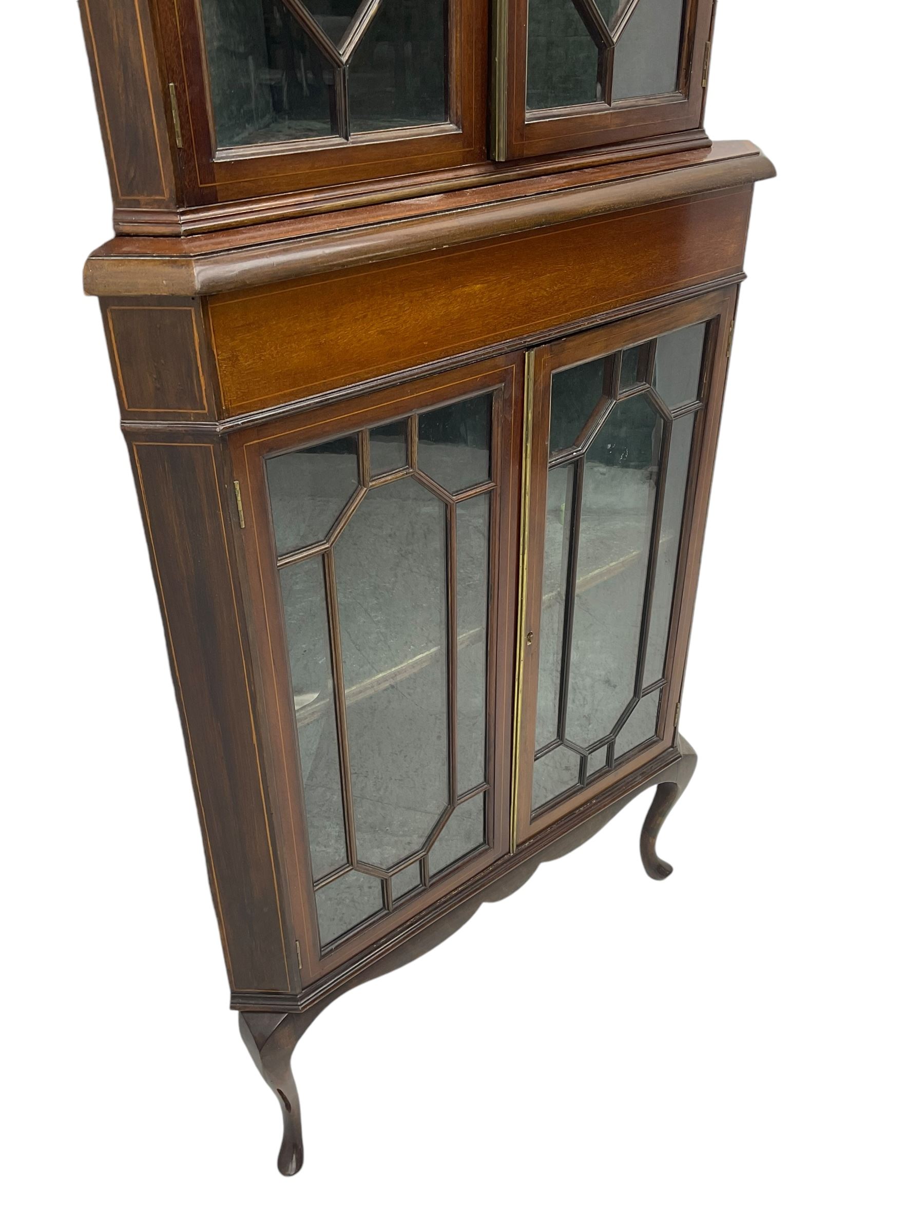 Edwardian mahogany corner display cabinet, scrolled swan neck pediment over astragal glazed doors, fabric lined interior, on cabriole feet 
