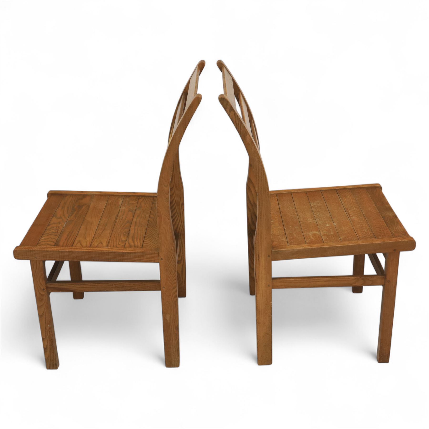 Treske of Thirsk - solid oak refectory dining suite, rectangular top with chamfered edge over trestle base united by a central stretcher, together with six matching slat back dining chairs, including two carvers, with panelled seats and square legs united by stretchers (H 87cm, W 62cm, D 57cm)
