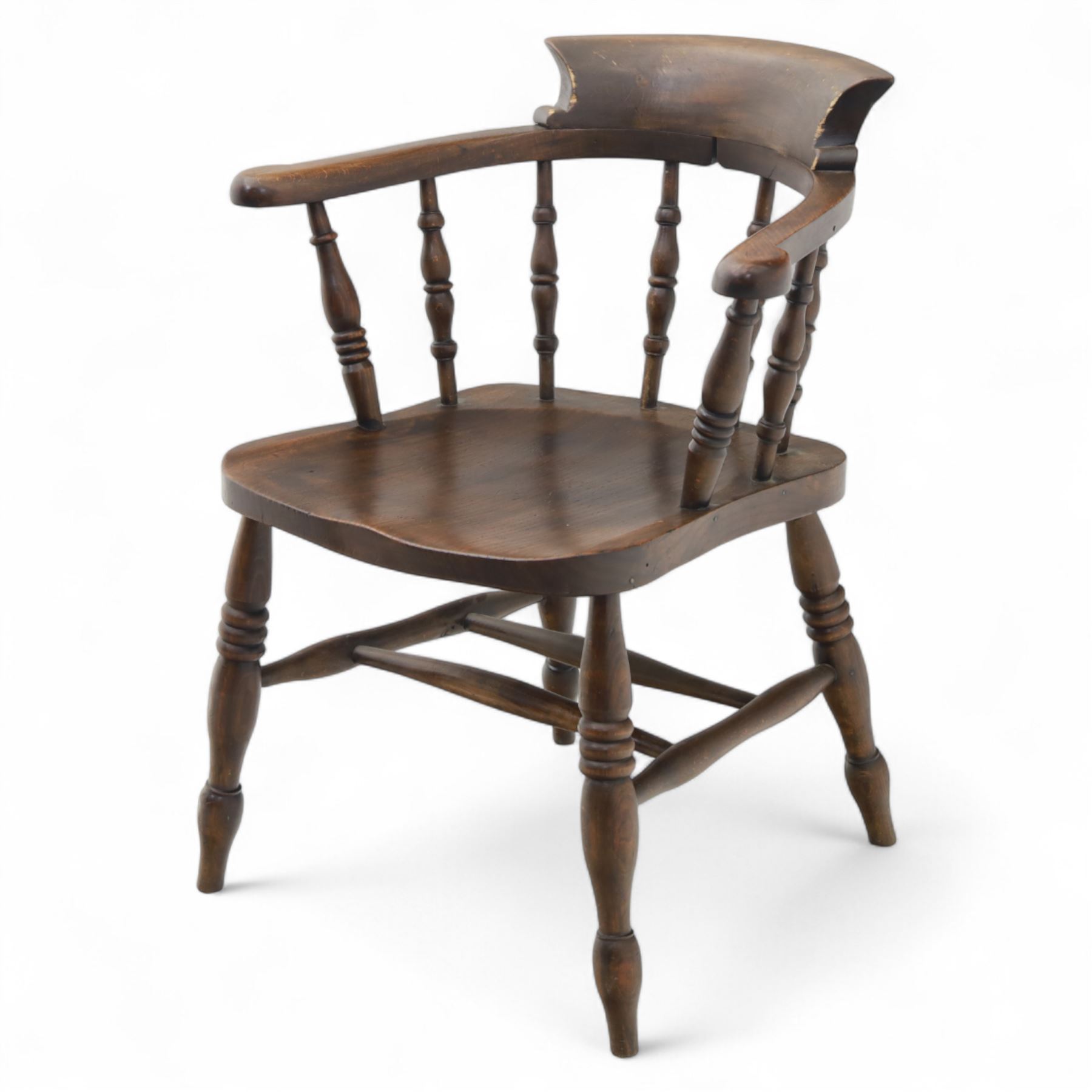 Early 20th century smokers bow armchair, shaped and curved top rail over turned spindles and open arms with rounded terminals, shaped elm seat on turned supports