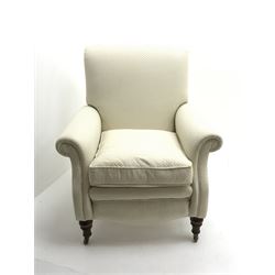 Victorian style scroll back armchair upholstered in cream fabric, turned supports on castors