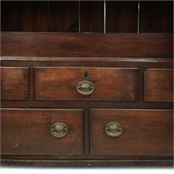 18th century oak dwarf press cupboard, the upper section with twin arched panel doors above three short and two long drawers, each with brass plate handles, shaped apron and stile feet, of compact country form
