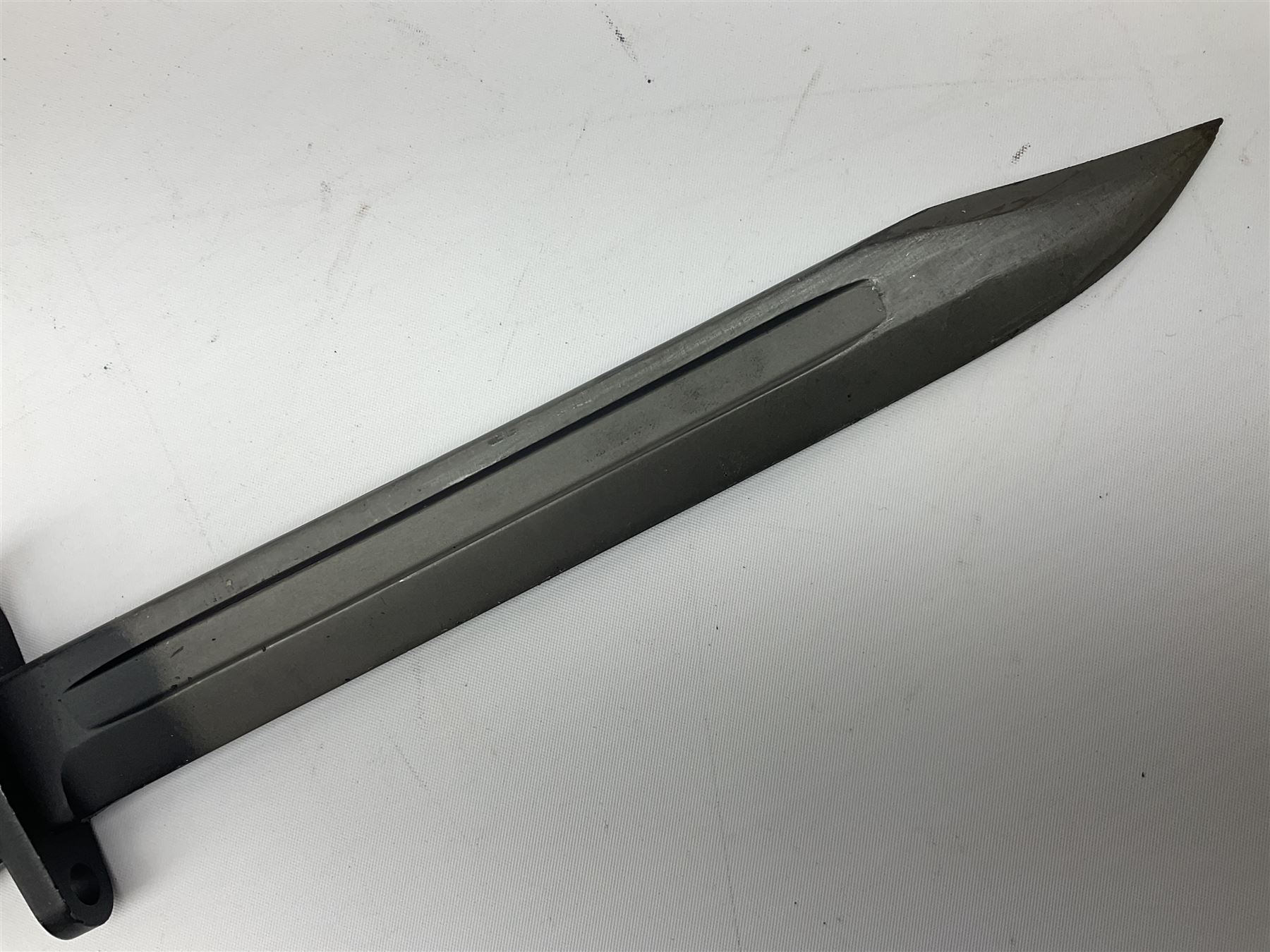 British Army L1A3 SLR Self Loading Rifle bayonet, with 20.5cm Bowie type fullered blade, hooked pommel with working push release button, grip secured by two deeply recessed rivets and marked L1A3 9600257 D71; in matching black scabbard L32.5cm overall