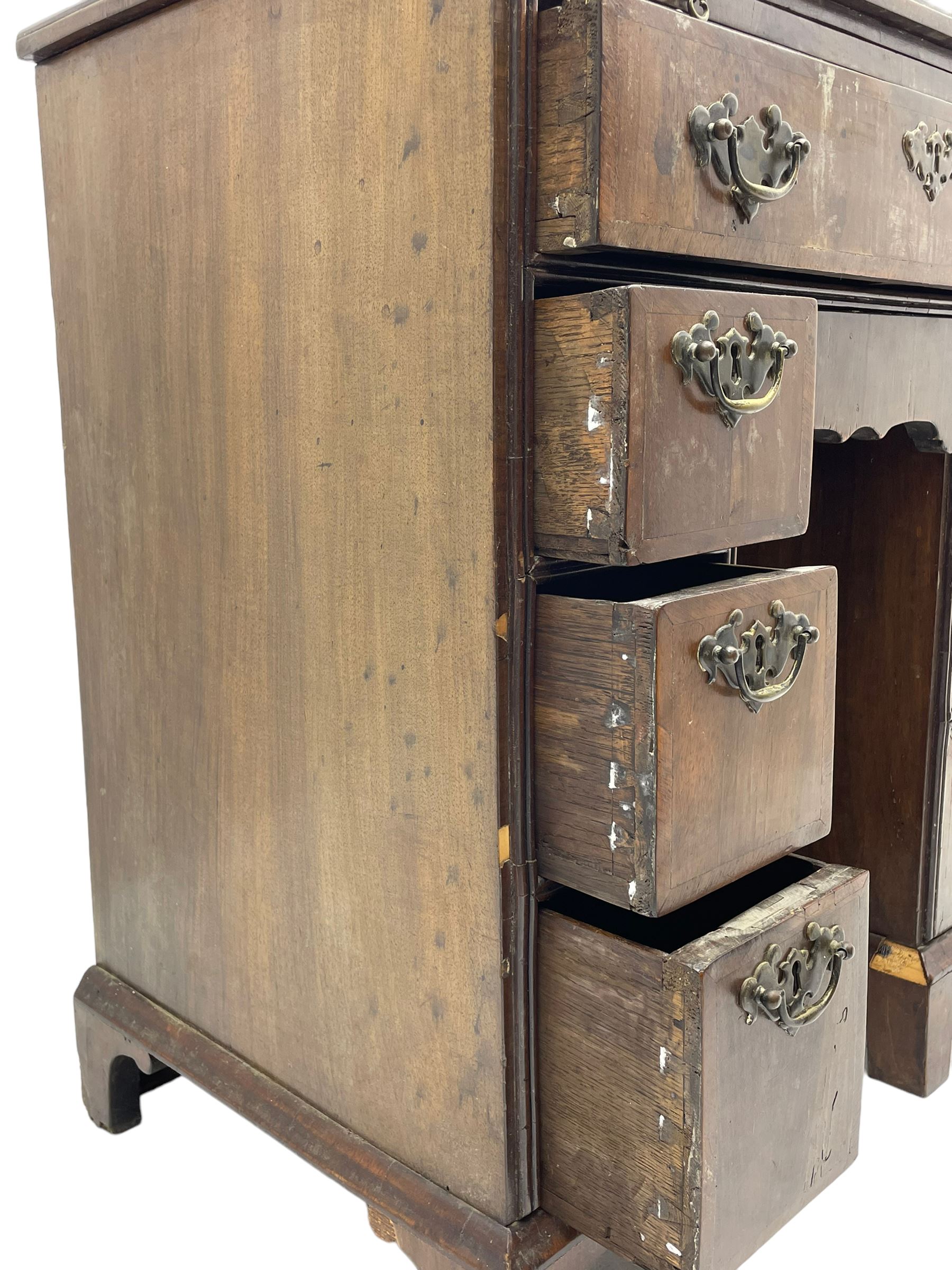 Georgian walnut kneehole desk, moulded rectangular top with book-matched veneers within crossbanding, fitted with slide over one long drawer, frieze drawer, six small drawers and recessed cupboard, raised on bracket feet