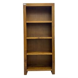 Contemporary Dakota mango wood open bookcase, rectangular form with four fixed open shelves, raised on stile supports