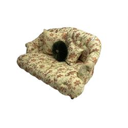 Victorian style two seat sofa, upholstered in beige ground floral floral pattern fabric, with scatter cushions, turned feet with brass castors