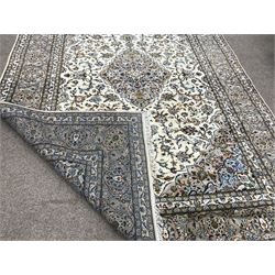 Keshan beige ground rug, central medallion, floral field repeating border