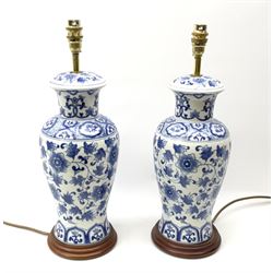 A pair of blue and white Oriental style table lamps, of baluster form with foliate decoration, including fittings H47.5cm.