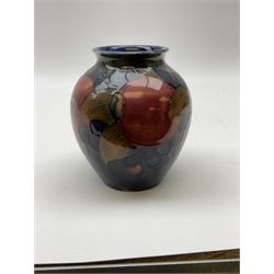 Moorcroft vase of baluster form, decorated in Pomegranate and Berries pattern upon a dark blue ground, with impressed marks beneath, H10.5cm.