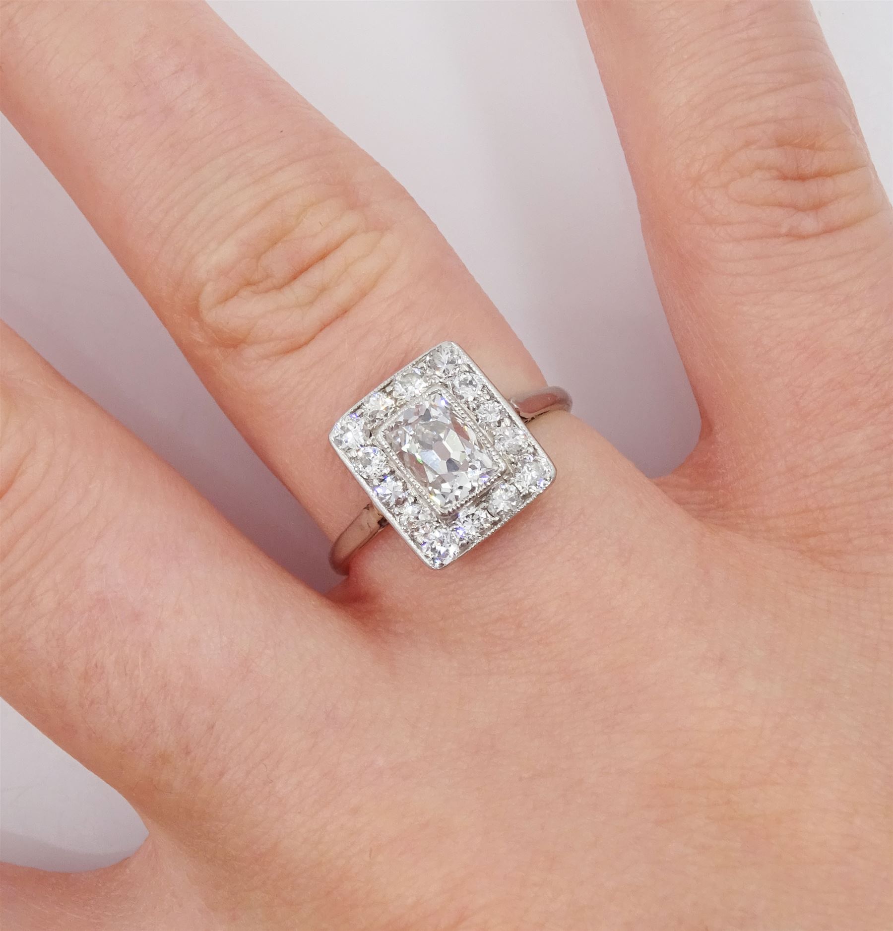 Art Deco platinum and white gold milgrain set diamond ring, circa 1920's, the central cushion cut diamond of approx 0.90 carat, with old cut diamond surround, total diamond weight approx 1.10 carat