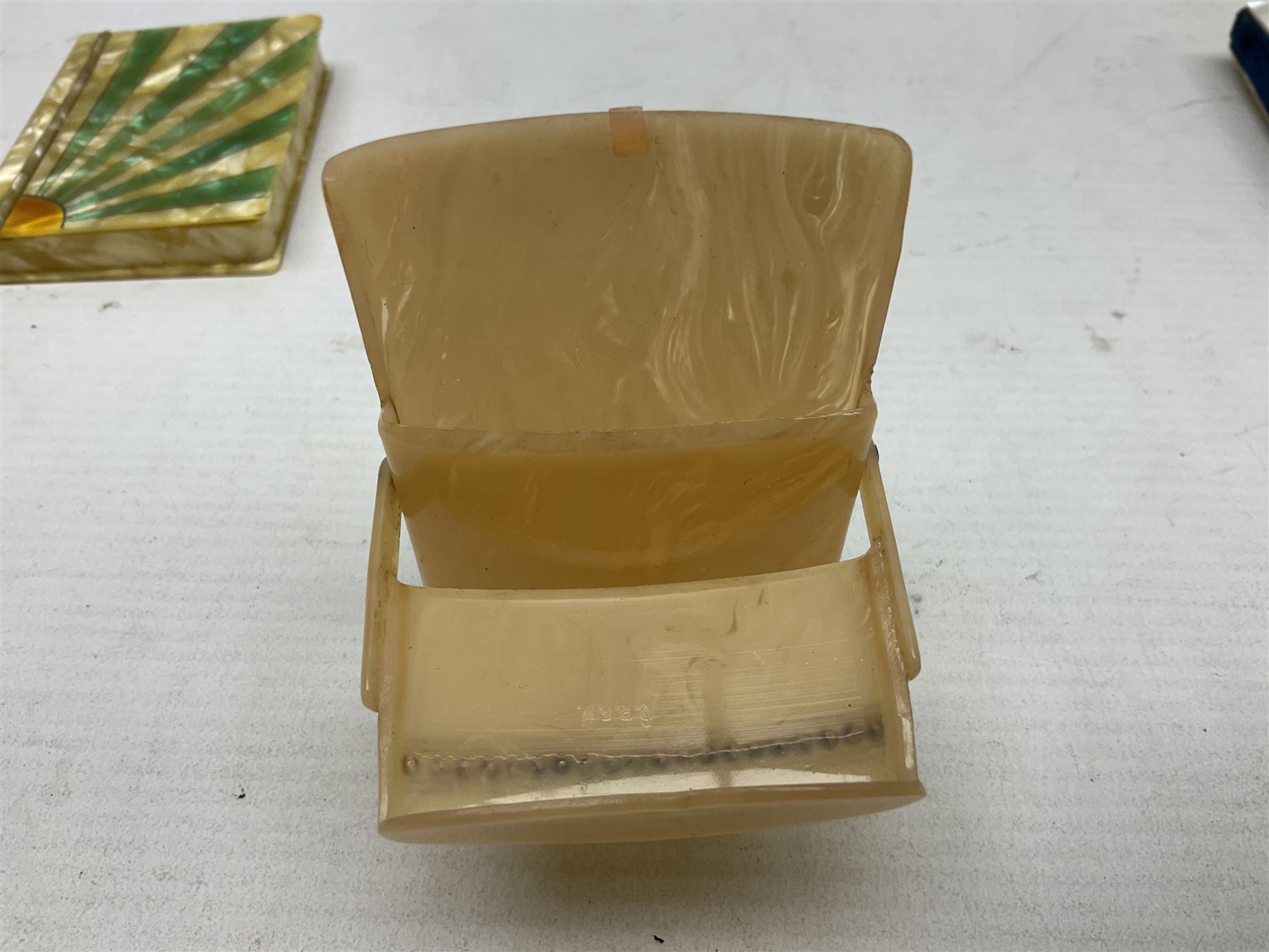 Mother of pearl and abalone inlaid card case, with central diamond shaped panel engraved with foliate decoration, together with a simulated mother of pearl card case of book form with green sun rays to cover, and simulated wood effect cigarette case with hinged lid with diamante style banding, largest L10cm