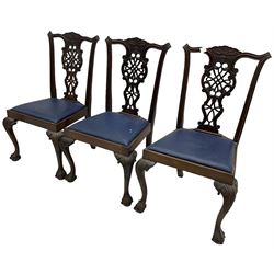 Set of six (5+1) Chippendale design mahogany dining chairs, shaped cresting rail over pierced splat with elaborately carved foliate and scrolling decoration, over drop-in upholstered seats, raised on cabriole supports with scrolled acanthus carved knees and ball and claw carved terminals