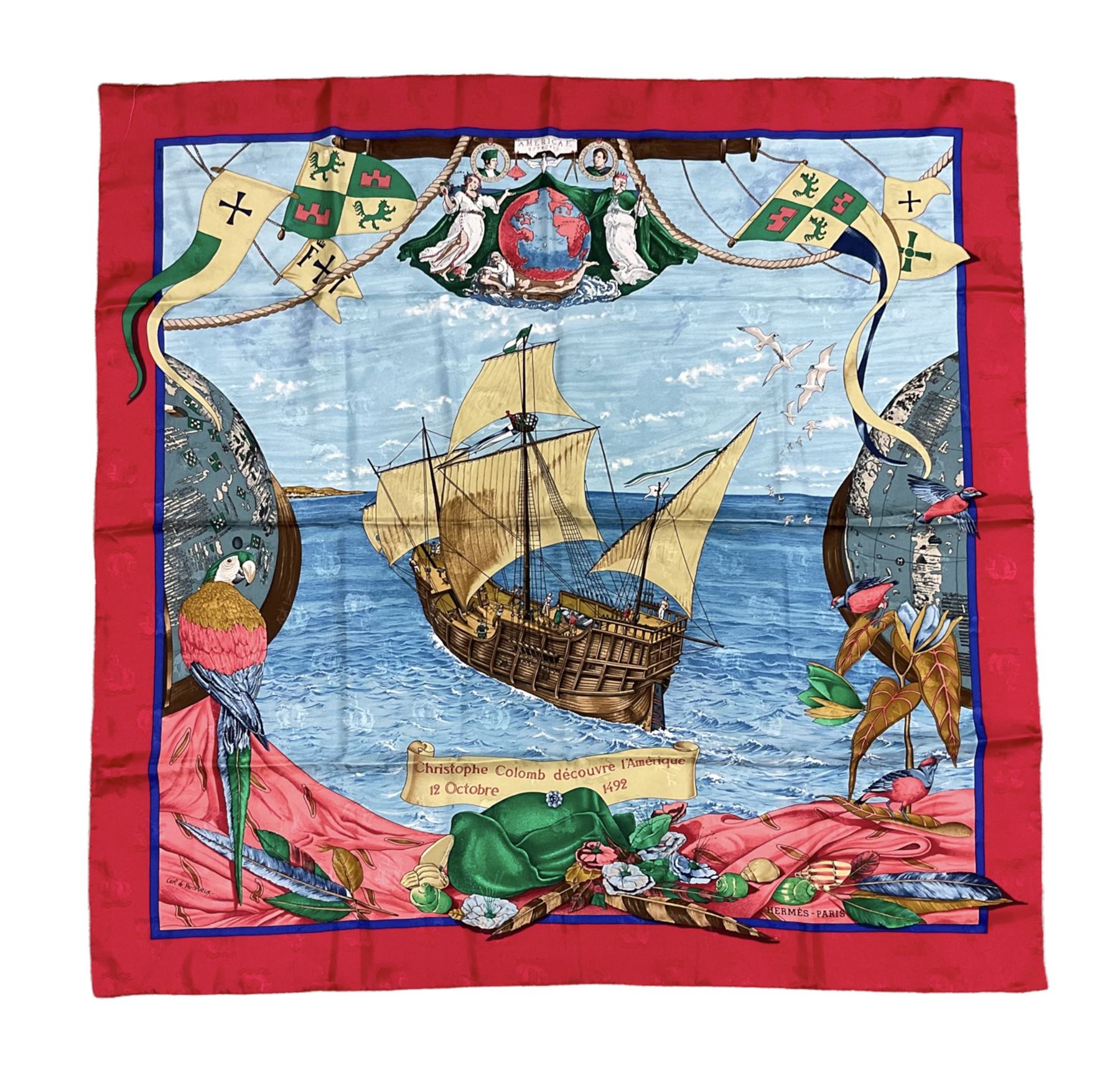 Hermès 'Christophe Colomb Découvre l'Amérique' jacquard silk scarf, designed by Carl de Parcevaux in 1992, limited edition for the bi-centenary of the discovery of America, printed with a central image of Christopher Columbus' ship at sea, surrounded with colourful stylised feathers, birds, flags, globes, shells and flowers, contained within vibrant red border, with rolled hand stitched edges and Hermes material label, 87cm square