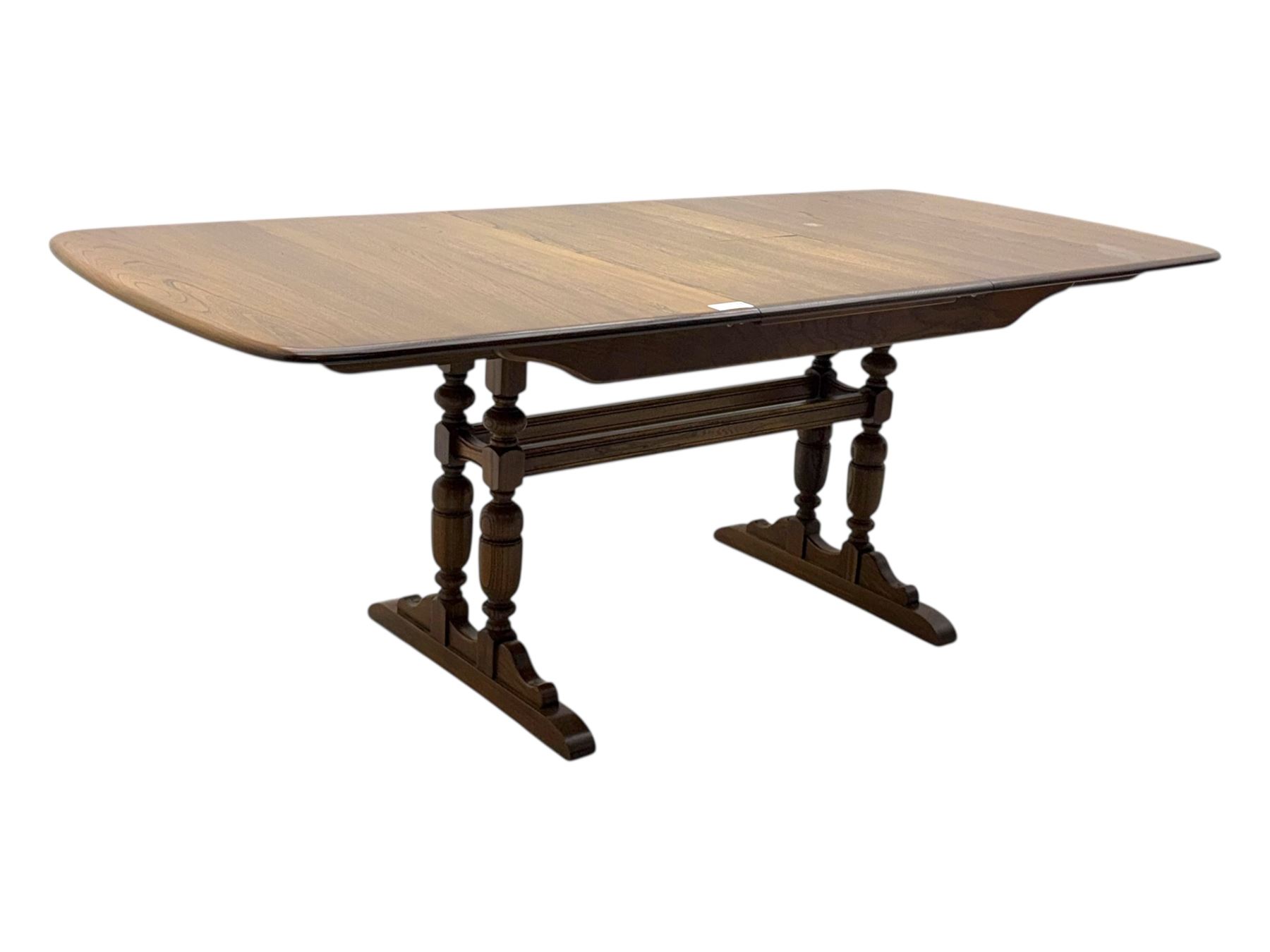 Ercol - late 20th century oak refectory dining table, rectangular top with rounded corners and central extending leaf, raised on turned baluster supports united by a stretcher (Extended 200cm)