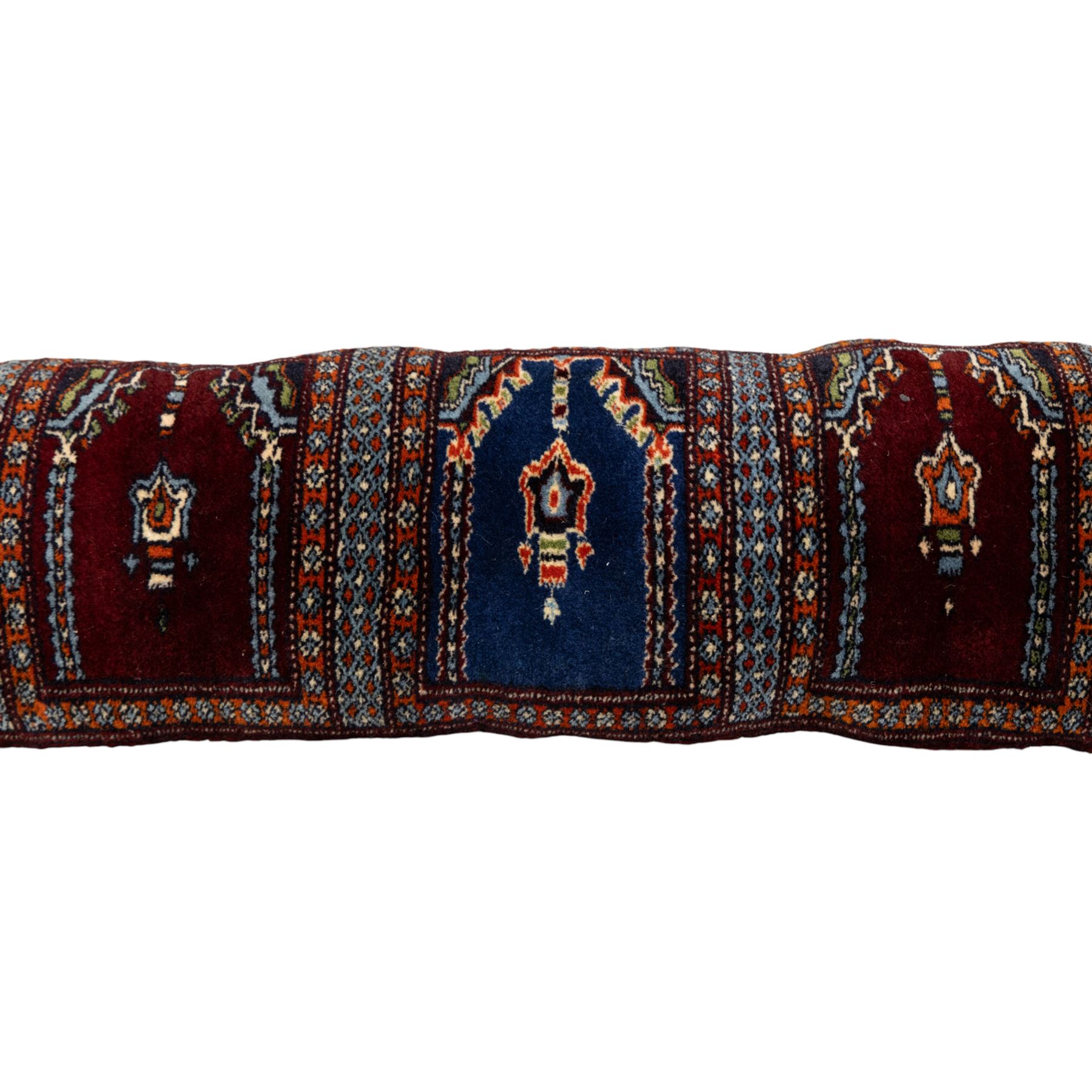 Long flatweave Kilim textile cushion, in crimson and decorated with geometric motifs and cotton fringe ends, 151cm, together with four modern hand-knotted rug mats with geometric designs, the largest 65x43cm, (5)