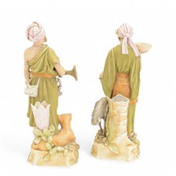 Pair of Royal Dux spill vase figures, modelled as a huntsman and water carriers, each with exotic animals to the base, H45cm