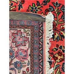 North West Persian Sarouk peach ground rug, the field decorated with floral bunches, pale ground border with repeating flower head motifs within guard stripes 