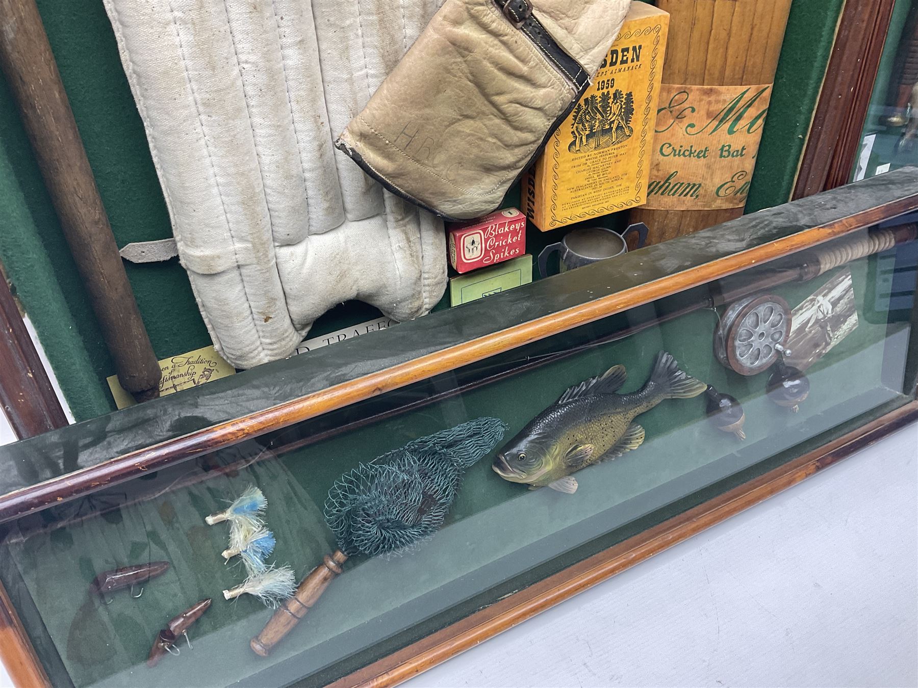 Four framed sporting memorabilia displays, the largest example containing 1930s cricket memorabilia, together with two fishing displays and a football display, each within wooden glazed frames, largest H105cm